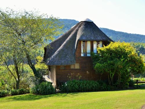 a small wooden house with a thatched roof at ANEW Resort Ingeli Forest Kokstad in Kokstad