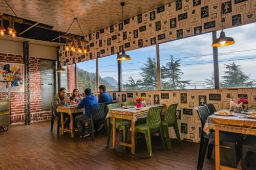 a group of people sitting at tables in a restaurant at FabHotel Sizzling Resort & Adventure - Nr Main market in Dhanaulti