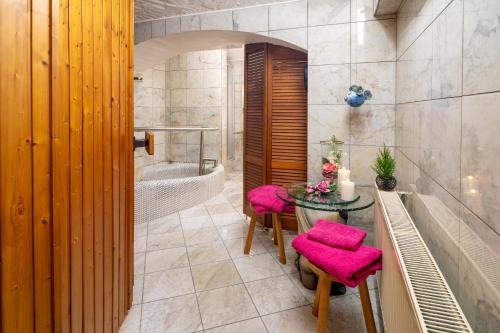 a bathroom with a table and chairs and a tub at Lux Ferienwohnung altes Landwarenhaus mit Garten und zubuchbarer Sauna in Hedersleben