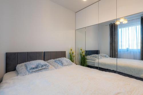 a bedroom with two beds and a large mirror at Gicek Apartament 11A bezpłatny PARKING Faktura VAT 4 osobowy K-S SSE in Gorzów Wielkopolski