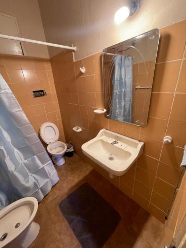 a bathroom with a sink and a toilet and a mirror at La Casona in Posadas