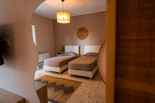 a hotel room with two beds and a hallway at Casa Manbrù by Studio Vita in Siculiana