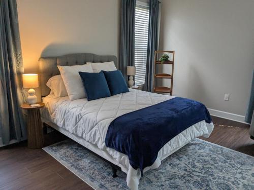 une chambre avec un grand lit avec des oreillers bleus dans l'établissement Serenity Cottage, à Thomasville