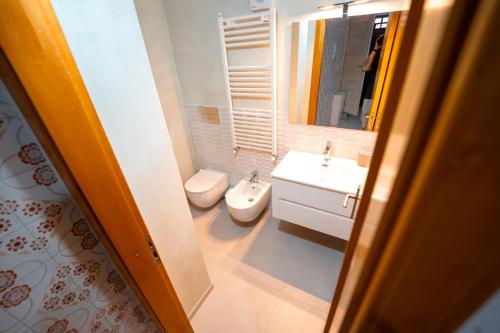 a bathroom with a toilet and a sink and a mirror at Casa Manbrù by Studio Vita in Siculiana