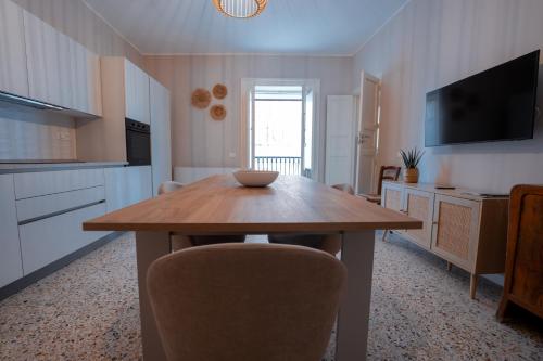 a kitchen and dining room with a wooden table at Casa Manbrù by Studio Vita in Siculiana