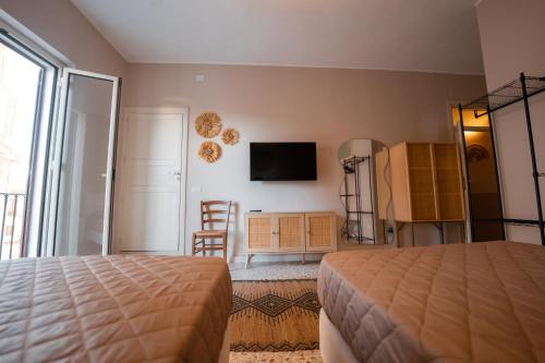 a bedroom with a bed and a tv on the wall at Casa Manbrù by Studio Vita in Siculiana
