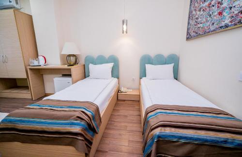 two beds in a small room with at Guci Hotel in Constanţa