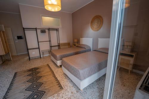 a bedroom with two beds and a rug at Casa Manbrù by Studio Vita in Siculiana