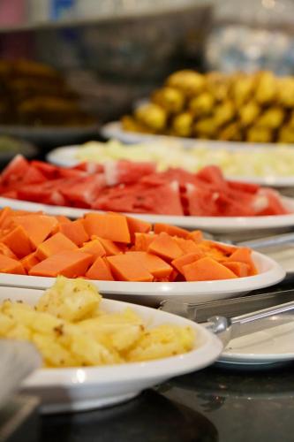 a table topped with plates of different types of food at Pousada Familly Porto de Galinhas in Porto De Galinhas