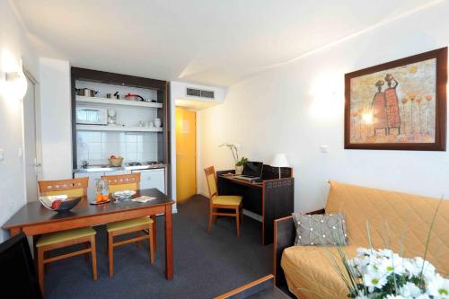 a hotel room with a desk and a room with a bed and a deskicter at Aparthotel Adagio Access Toulouse Jolimont in Toulouse