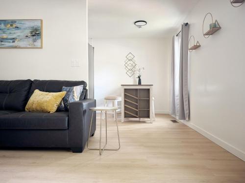 a living room with a black couch and a table at Cypress Suites - Stylish apartments in Newburgh IN in Newburgh
