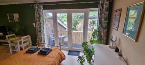 a bedroom with a bed and a large window at Fern Studio in Lyme Regis