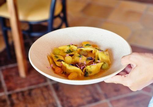 a person holding a white bowl of food at Hotel Ecolife Tenerife in San Miguel de Abona
