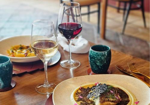 a table with a plate of food and two glasses of wine at Hotel Ecolife Tenerife in San Miguel de Abona