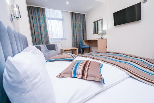 a hotel room with two beds and a television at Guci Hotel in Constanţa