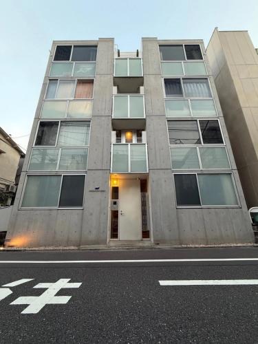 a tallartment building on a city street with a road at 201Room,7-minute walk from Uguisudani Station located on the 2nd floor of an apartment-style building Twin room No elevator in Tokyo