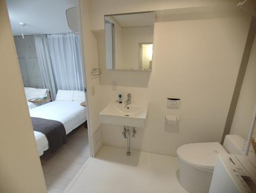 东京201Room,7-minute walk from Uguisudani Station located on the 2nd floor of an apartment-style building Twin room No elevator的浴室里有洗手池、马桶和镜子。