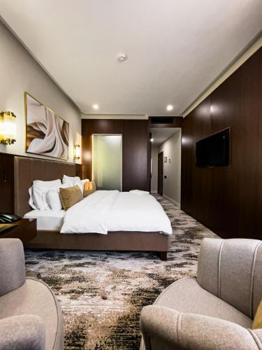 a bedroom with a large bed and a flat screen tv at Kazakhstan Hotel in Almaty