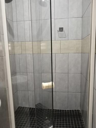 a shower with a glass door in a bathroom at Capital Park entire rental unit in Pretoria