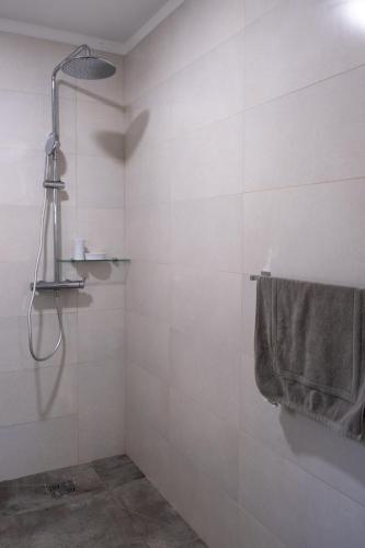 a bathroom with a shower and a towel on a wall at La Villa Day **** in Les Cocos