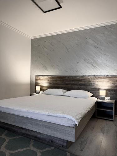 a bedroom with a large bed with a wooden headboard at Relax House El Passo in Târgu-Mureş