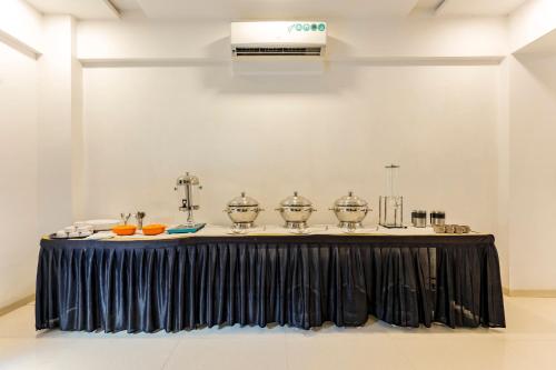 a black table with silver dishes on it at Treebo Blue Roof, Kelwa in Pālghar