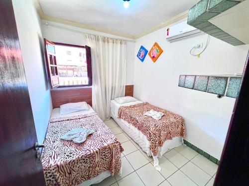 a room with two beds and a window at Pousada Familly Porto de Galinhas in Porto De Galinhas