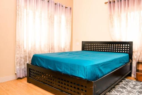 a bed in a room with a blue mattress at The Edge in Accra