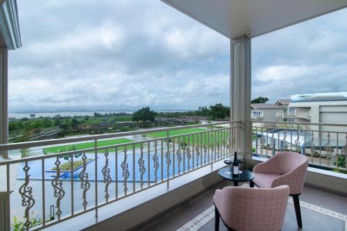 a balcony with two chairs and a view of the water at The Haven by Sula in Nashik