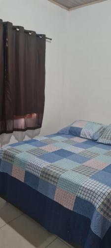 una cama en una habitación con una manta de cuadros azules en Apartamentos da Casa Azul, en Trancoso