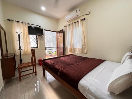 a bedroom with a bed and a tv and a window at The cozy Inn in Calangute
