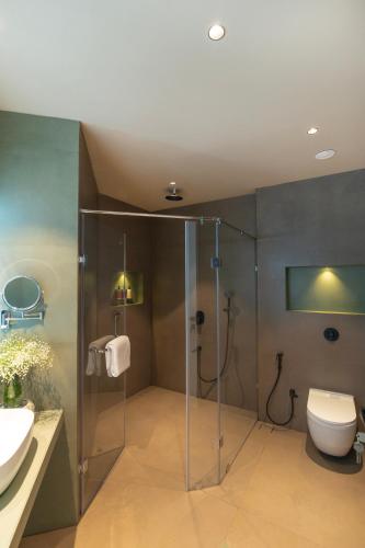a bathroom with a shower and a toilet and a sink at The Haven by Sula in Nashik
