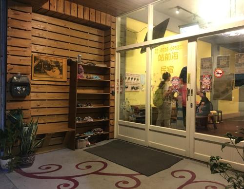 a woman standing outside of a store window at 站前海民宿 in Hualien City