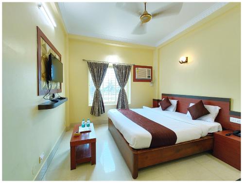 a hotel room with a bed and a television at SEA VIEW FAMILY HOTEL ANNAPURNA INN RESORT - Near Sea Beach - Jagarnath Temple - Golden Swargadwar Beach - Parking & Wi-Fi Facilities - Fully Air Conditioned Hotel in Prime location - Best Hotel In puri in Puri