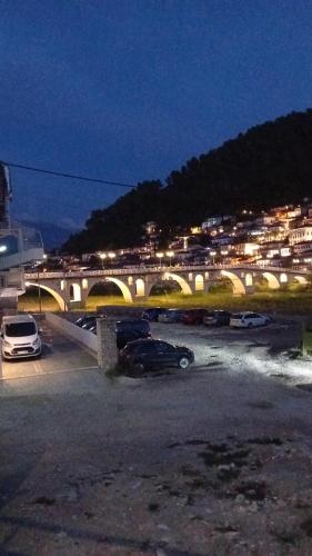 a bridge with cars parked in a parking lot at night at Villa Rexho in Berat