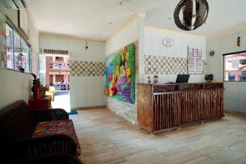 a living room with a large painting on the wall at Pousada Familly Porto de Galinhas in Porto De Galinhas