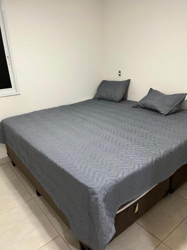 Cama grande en habitación blanca con 2 almohadas en Brookfield Towers 2912A, en Goiânia