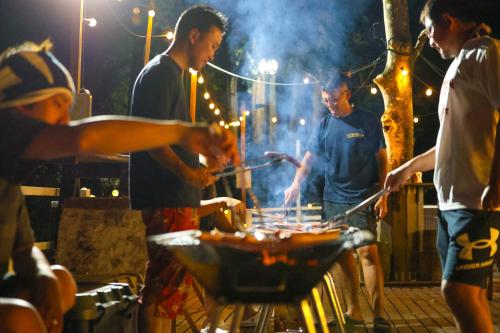 a group of people cooking food on a grill at Showa Forest Village in Chiba
