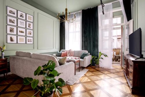 Una sala de estar con un sofá y un televisor. en TurnKey I Antonin Dvorak Apartments, en Praga