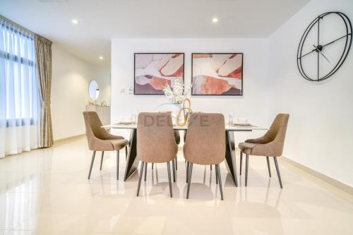 a dining room with a table and chairs at Luxurious 4-Bedroom Villa with Assistant Room and Private Pool in Al Dana Island, Fujairah by Deluxe Holiday Homes in Fujairah