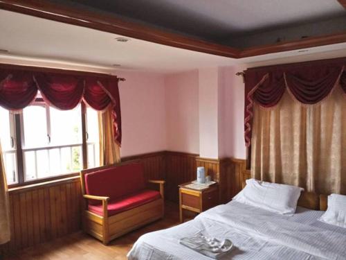 una camera da letto con un letto, una sedia e una finestra di Hotel The Golden Ice a Pelling