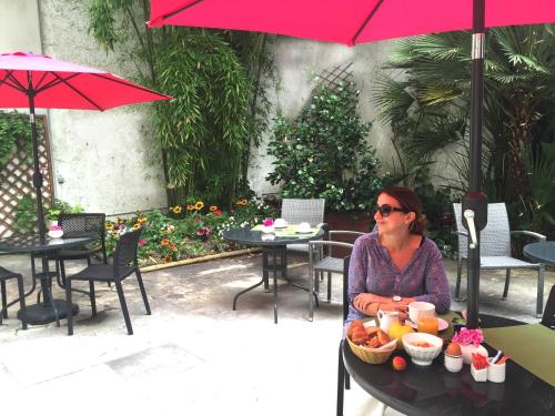 Eine Frau, die an einem Tisch mit einer Schüssel Essen sitzt. in der Unterkunft Hôtel Orchidée in Paris