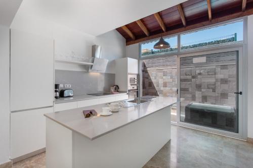 a kitchen with white counters and a large window at Casa Alicia in Corralejo