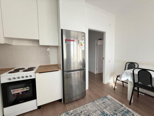 una cucina con frigorifero in acciaio inox e tavolo di Skyline a Tridtsatʼ Let Kazakhstana