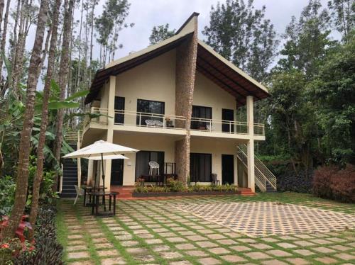 a house with a patio in front of it at Shola Vibes Homestay in Chikmagalūr