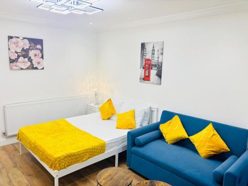 a bedroom with a bed and a blue couch at Royal Wharf Inn in London