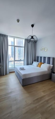 a bedroom with a large bed and a large window at Spacious Apartment Marina View in Dubai