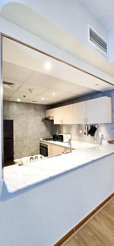 a kitchen with white cabinets and a large mirror at Spacious Apartment Marina View in Dubai