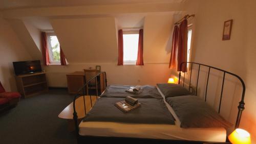 a bedroom with a bed with two books on it at Pension Zlata Noha in Bratislava