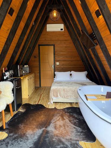 a bedroom with a bed and a tub in a attic at Chalet with Private Jacuzzi and View of the Jucu River in Domingos Martins